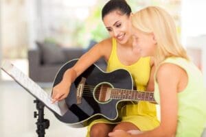 Guitar teacher helping a student