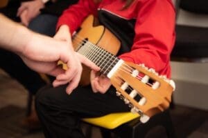 Guitar teacher instructing a student